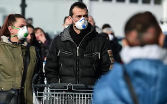 Residents wearing a respiratory mask wait to be given access to shop in a supermarket in small groups of forty people on February 23, 2020 in the small Italian town of Casalpusterlengo, under the shadow of a new coronavirus outbreak, as Italy took drastic containment steps as worldwide fears over the epidemic spiralled. (Photo by Miguel MEDINA / AFP) (Photo by MIGUEL MEDINA/AFP via Getty Images)