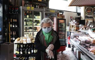 ROME, ITALY - MARCH 11: Tiziana from the Cataldi grocery store is preparing to open the shop wearing a protective mask and gloves on March 11, 2020 in Rome, Italy. 
The Italian Government has taken the unprecedented measure of a nationwide lockdown, in an effort to fight the world's second-most deadly coronavirus outbreak outside of China. Pubs, cafes and restaurants closed from six in the evening.
The movements in and out are allowed only for work and health reasons proven by a medical certificate. The beauty and wellness centers and spas have been closed, all staff who work in contact with the public or who work in grocery stores are obliged to wear protective masks and gloves. Citizens have an obligation to respect the safety distance of one meter from each other in a row at supermarkets or in public businesses.
(Photo by Marco Di Lauro/Getty Images)