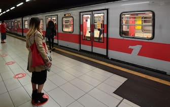 A commuter stands on a red circle on the ground indicating where to stand to maintain distance between people, on May 4, 2020 at the Cardona underground metro station in Milan, as Italy starts to ease its lockdown, during the country's lockdown aimed at curbing the spread of the COVID-19 infection, caused by the novel coronavirus. - Stir-crazy Italians will be free to stroll and visit relatives for the first time in nine weeks on May 4, 2020 as Europe's hardest-hit country eases back the world's longest nationwide coronavirus lockdown. (Photo by Miguel MEDINA / AFP)