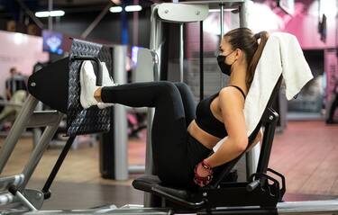 11 May 2020, North Rhine-Westphalia, Cologne: A woman with a mouth guard is training on a leg press in a fitness studio of the McFit chain. In NRW, the first gyms have reopened after their corona break in the night from Monday to Monday. Photo: Marius Becker/dpa (Marius Becker / IPA/Fotogramma, Cologne - 2020-05-11) p.s. la foto e' utilizzabile nel rispetto del contesto in cui e' stata scattata, e senza intento diffamatorio del decoro delle persone rappresentate