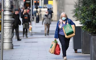 epa08762242 A woman wearing a face mask carries shopping in Dublin City, Ireland, 21 October 2020. The Irish government has announced level 5 restrictions for the whole country from 22 October 2020, which will see all unessential retail shops, restaurants, and bars close for six weeks. Cases of COVID-19 have been rising in Ireland for the past number of weeks.  EPA/AIDAN CRAWLEY