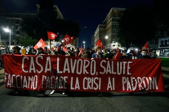 Manifestanti con uno striscione durante la protesta per il reddito universale 'Tu ci chiudi tu ci paghi', Roma, 31 ottobre 2020. ANSA/RICCARDO ANTIMIANI