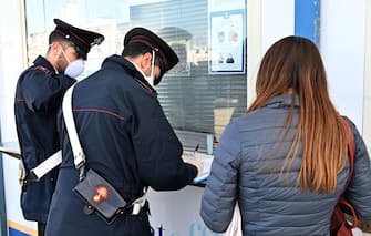 Passeggeri arrivati da Reggio Calabria a bordo degli aliscafi delle Ferrovie dello Stato in attesa di controlli da parte delle Forze dell'Ordine e del personale sanitario. Messina, 14 marzo 2020. ANSA/CARMELO IMBESI