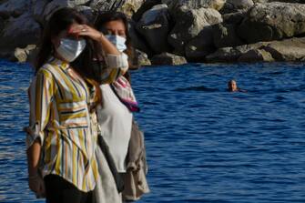 Tuffi e nuotate fuoristagione sul lungomare Caracciolo di Napoli dove il clima estivo, nonostante la pandemia covid-19,  ha invogliato migliaia persone a concedersi una passeggiata,  7  novembre  2020.
ANSA / CIRO FUSCO
