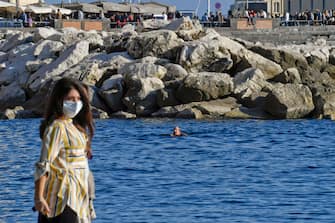 Tuffi e nuotate fuoristagione sul lungomare Caracciolo di Napoli dove il clima estivo, nonostante la pandemia covid-19,  ha invogliato migliaia persone a concedersi una passeggiata,  7  novembre  2020.
ANSA / CIRO FUSCO