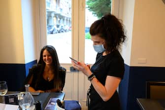 VINOVO, ITALY - JUNE 04: A waitress with protective mask at work during the reopening to the customers of a restaurant on June 04, 2020 in Vinovo, Italy. Many Italian businesses have been allowed to reopen, after more than two months of a nationwide lockdown meant to curb the spread of Covid-19. (Photo by Diego Puletto/Getty Images)
