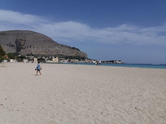 Diminuita la gente in spiaggia, ma rimane tanta tra i viali della borgata marinara di Mondello a Palermo, 10 maggio 2020. E' l'effetto dei controlli scattati da questa mattina da parte di polizia, carabinieri e capitaneria di Porto nel località balneare del capoluogo siciliano. ANSA/ IGNAZIO MARCHESE