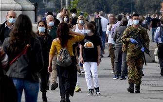 Un militare controlla i passanti invitandoli ad indossare la mascherina sul lungomare di Napoli a poche ore dall' applicazione dei limiti di circolazione per l'inserimento della Campania nelle area  di ' Zona Rossa'   14 novembre  2020
ANSA / CIRO FUSCO