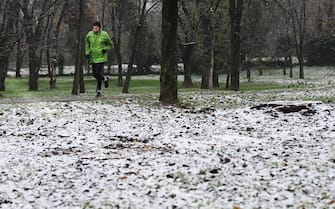 Una persona corre in un parco di San Donato Milanese ricorperto di un leggero strato di neve, 2 dicembre 2020. ANSA/DANIEL DAL ZENNARO