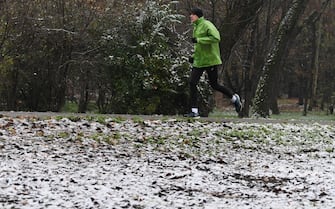 Una persona corre in un parco di San Donato Milanese ricorperto di un leggero strato di neve, 2 dicembre 2020. ANSA/DANIEL DAL ZENNARO