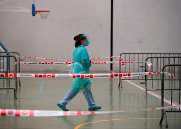 A healthcare worker waits for residents to collect samples from them at a temporary testing centre for the novel coronavirus in the Spanish Basque city of Getaria on July 15, 2020. - The novel coronavirus has killed at least 574,278 people since the outbreak emerged in China last December, according to a tally from official sources compiled by AFP at 1900 GMT yesterday. (Photo by ANDER GILLENEA / AFP) (Photo by ANDER GILLENEA/AFP via Getty Images)