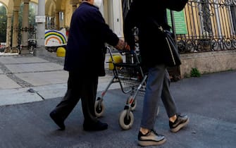 Donna anziana passeggia per le strade di Milano accompagnata