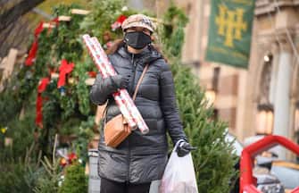 NEW YORK, NEW YORK - DECEMBER 11: A person carries gift wraps on the Upper West Side on December 11, 2020 in New York City.  Many holiday events have been canceled or adjusted with additional safety measures due to the ongoing coronavirus (COVID-19) pandemic. (Photo by Noam Galai/Getty Images)