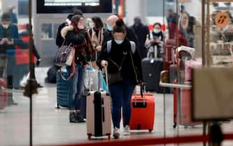 Persone in una stazione ferroviaria a Milano Passeggeri in transito in una stazione ferroviaria di Milano