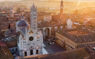 View on the Cathedral of the medieval town of Siena, left, and the "Il Mangia" main town, right, on sunrise during the lockdown emergency period aimed at stopping the spread of the Covid-19 coronavirus. Although the lockdown and full absence of people, the scenery of the Italian squares and monuments remain fascinating, Siena, Italy, 23 April 2020(ANSA foto Fabio Muzzi)