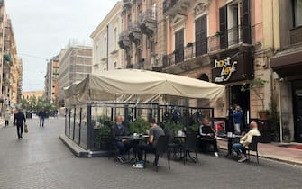 Primi clienti ai tavolini dei bar a Bari, 18 maggio 2020. ANSA