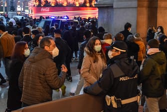 Police stand guard to control the crowd of people as they shop in the central area of Milan, Italy, 19 December 2020. Italian Premier Giuseppe Conte's government on 18 December announced restrictions that will put Italy into some form of a lockdown over the Christmas holidays to stop social contact during the festive season feeding a third wave of COVID-19 coronavirus pandemic in the country.  ANSA/MATTEO CORNER