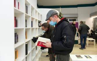 Una persona con il volto coperto da una mascherina consulta un libro in occasion della' apertura libreria Altaforte a Cernusco sul Naviglio, 5 dicembre 2020. AnsaYuriLaudadio