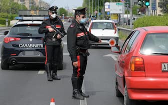 Carabinieri ed esercito controllano automobilisti e pedoni lungo la via Emilia per evitare spostamenti non autorizzati nel giorno di Pasquetta a San Donato Milanese, 13 aprile 2020. Ansa/Andrea Canali
