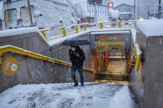 A man walks at piazza Lodi metro stop during snowfall in Milan, Italy, 28 December 2020. 
Ansa/Matteo Corner