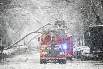 I vigili del fuoco lavorano dove gli alberi caduti lungo via Raffaello Sanzio  hanno tranciato i cavi del tram a Milano, 28 dicembre 2020.
ANSA/FOTOGRAMMA/Stefano De Grandis