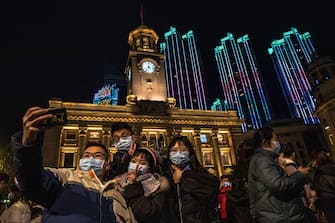 epa08912730 People take selfies as they celebrate the New Year in Wuhan, China, 01 January 2021. Life in Wuhan, a Chinese city of more than 11 million, which nearly a year ago became the epicenter of the coronavirus outbreak is returning to normal.  EPA/ROMAN PILIPEY