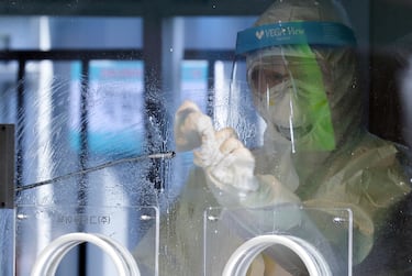 epa08914899 After conducting a coronavirus test, a health worker disinfects a testing facility set up in front of Seoul Station in central Seoul, South Korea, 02 January 2021.  EPA/YONHAP SOUTH KOREA OUT