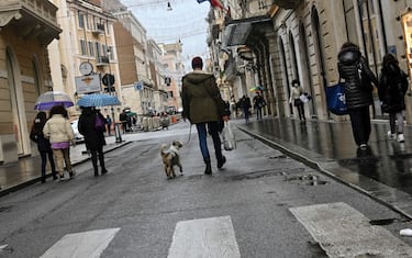 Alcune persone in giro per i negozi di via del Corso nel centro di Roma, approfittando del ritorno della "zona arancione" nonostante la pioggia a Roma, 28 dicembre 2020. ANSA/RICCARDO ANTIMIANI