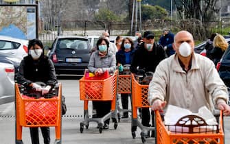 Customers, wearing medical masks to protect themselves from any coronavirus infection, keep in line outside a supermarket in Naples, Italy, 21 March 2020.
ANSA / CIOR FUSCO