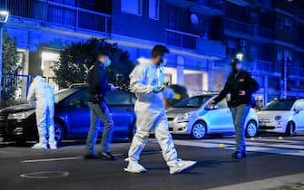 Agenti della polizia e della Scientifica sul luogo dove un uomo che  ha aggredito dei passanti per strada, armato di un grosso coltello, è stato ucciso dagli agenti intervenuti a  Milano,  23 Febbraio,  2021. 
ANSA/Andrea Fasani