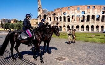 ROME, ITALY - APRIL 09: Mounted policemen patrol and two soldiers of the Italian Army  check the area around the the Colosseum area (Colosseo), closed and without tourists, during the Coronavirus emergency on April 09, 2020 in Rome, Italy. There have been well over 100,000 reported COVID-19 cases in Italy and more than 15,000 related deaths, but the officials are confident the peak of new cases has passed. (Photo by Stefano Montesi - Corbis/ Getty Images)