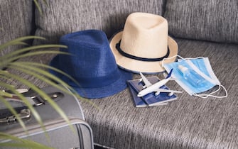 Prepairing for travel after the end of quarantine Passports, hats, face masks and hand sanitizer Flight rules during coronavirus pandemic.