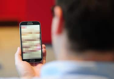 PICTURE POSED BY MODEL Undated photo of a man looking at a mobile phone. Clarification is needed on the law around "revenge porn" and when it could lead to a prosecution, a committee of peers has said.   (Photo by PA Images via Getty Images)