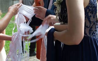 Invitati distribuiscono mascherine durante un matrimonio