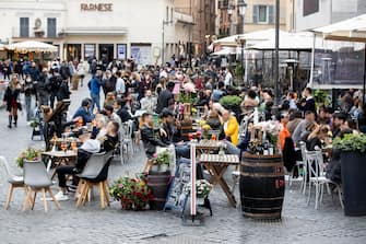 People eat at outdoor tables in Campo de' Fiori, Rome, Italy, on the occasion of Labor Day, 01 May 2021. COVID-19 restrictions have been eased in most of Italy with the reintroduction of moderate-risk yellow zones into the nation's tiered system of coronavirus-prevention measures. ANSA/ MASSIMO PERCOSSI