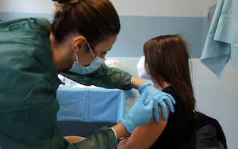 Una donna viene vaccinata all ospedale militare di Milano dove si sta provvedendo a inoculare il vaccino al personale sanitario. MIlano , 15 Febbraio  2021.ANSA / MATTEO BAZZI