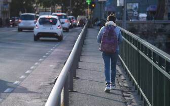 Uno studente cammina su un passaggio pedonale di una strada di Genova