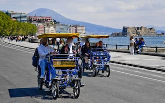 Cittadini a passeggio sui risciò sul lungomare Caracciolo a Napoli
