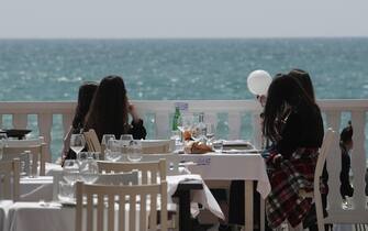 Ragazze a pranzo in un ristorante in un lido di Ostia