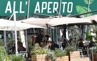 Riaperti i ristoranti all'aperto Persone pranzano sedute ai tavoli di un bar-ristorante, Milano, 17 maggio 2021. Gli esercizi commerciali in mercati e centri commerciali, gallerie e parchi commerciali nelle giornate festive e prefestive riapriranno dal 22 maggio, nel primo weekend successivo al decreto legge Covid. ANSA/DANIEL DAL ZENNARO