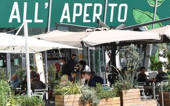 Persone pranzano sedute ai tavoli di un bar-ristorante, Milano, 17 maggio 2021. Gli esercizi commerciali in mercati e centri commerciali, gallerie e parchi commerciali nelle giornate festive e prefestive riapriranno dal 22 maggio, nel primo weekend successivo al decreto legge Covid. ANSA/DANIEL DAL ZENNARO 