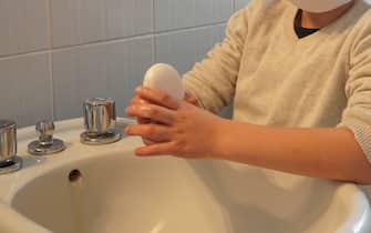 Milano - Emergenza Novel coronavirus - Bambino con mascherina  in quarantena si lava le mani con sapone