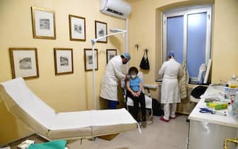 Personale sanitario esegue un vaccino anti-Covid in una farmacia di Genova