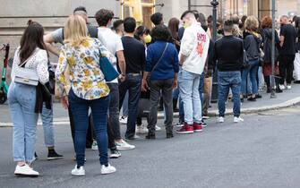 Persone in fila davanti ai negozi nel centro di Roma