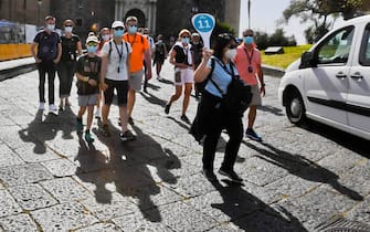Una guida turistica e un gruppo di turisti davanti al Maschio Angioino, a Napoli