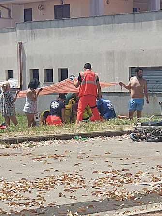 Alcune persone sul luogo di una sparatoria ad Ardea Nella foto per gentile concessione di Etruria News, i medici del servizio 118 tentano di rianimare i bambini coinvolti nella sparatoria, Ardea (Roma), 13 giugno 2021.
ANSA/Etruria News