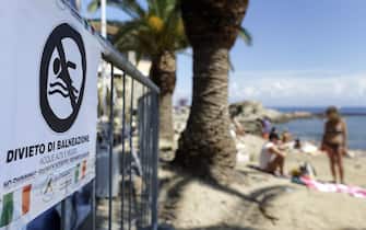 Cartelli per il divieto di balneazione all'ingresso della spiaggia vicino al Porto del Giglio dopo la rimozione della Costa Concordia, Isola del Giglio,  24 luglio 2014.
ANSA/RICCARDO ANTIMIANI