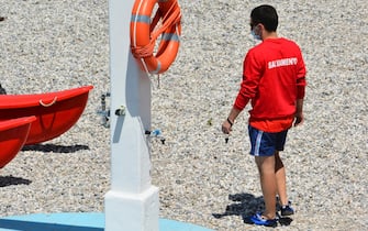 Un bagnino al lavoro in spiaggia Bagnino con mascherina al Bagno Pedocin a Trieste. Trieste, 1 Giugno 2020. ANSA/Mauro Zocchi