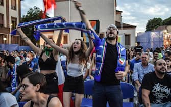 Tifose e tifosi dell'Italia con sciarpe e bandiere davanti a un maxi-schermo, a Milano, durante Euro 2020