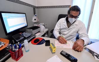 A general practitioner fills out a prescription in his office in Rome, 30 October 2020. ANSA / ETTORE FERRARI